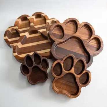 Wooden paw-shaped serving trays in various sizes, perfect for pet lovers or unique kitchen decor.