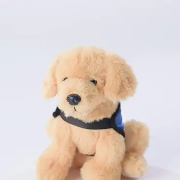 Fluffy toy dog with blue harness on white background, perfect for kids' gifts or playful decor.