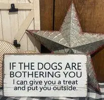 Humorous sign: If the dogs are bothering you, I can give you a treat and put you outside with rustic decor.