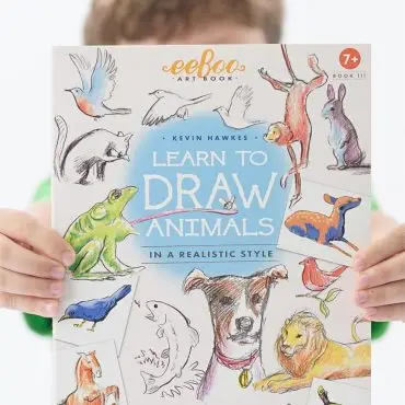 Child holding Learn to Draw Animals art book by Kevin Hawkes, featuring realistic animal sketches.