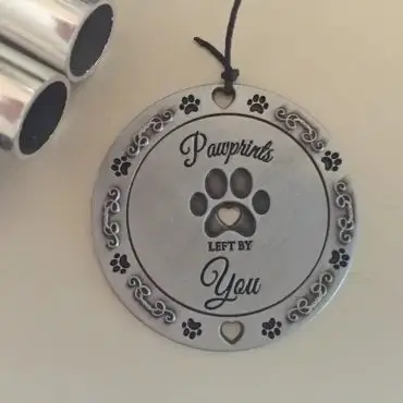 Round keepsake with Pawprints Left by You design, featuring paw prints and decorative heart accents.