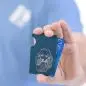 Man holding a blue minimalist wallet with poodle engraving, displaying a blue credit card partially inserted.