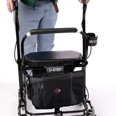Person using a U-Step walker with storage pouch, designed for mobility assistance.