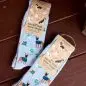 Blue socks with dog patterns, labeled socks that save dogs, placed on a wooden surface.
