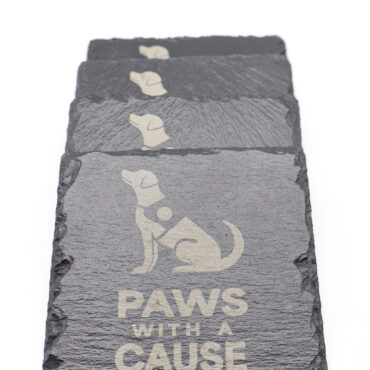 Black slate coasters with dog silhouette and Paws with a Cause logo, stacked on a white background.