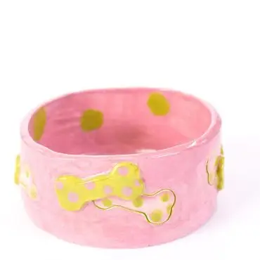 Pink ceramic pet bowl with yellow polka-dotted bone design, ideal for stylish pet feeding.