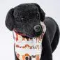 Plush black dog toy with cute dog-patterned bib on white background.