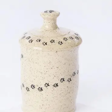 Speckled ceramic jar with paw print design on a white background, ideal for dog treats or kitchen storage.