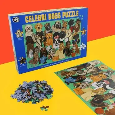 Celebri Dogs Puzzle box with completed dog-themed puzzle and scattered pieces on colorful background.