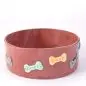 Ceramic dog bowl with colorful bone-shaped decorations and engraved commands: Sit, Stay, Come, Leave it.