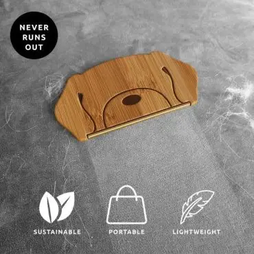 Bamboo pet hair remover on fabric, highlighting its sustainable, portable, and lightweight features.