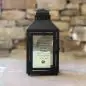 Black lantern displaying a heartfelt pet memorial quote against a rustic stone background.