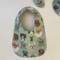 Baby bib featuring cute dog illustrations on a blue background, perfect for mealtime and keeping clothes clean.