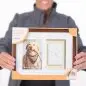 Person holding a Pawprints wall frame with a dog photo and clay paw impression, suitable for pets.