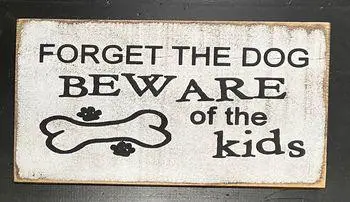 Humorous sign with text Forget the dog, beware of the kids and a bone illustration with paw prints.