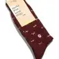 Maroon socks with small dog patterns and a paw print emblem, labeled socks that save dogs from Conscious Step.