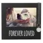 Dog in a black frame labeled Forever Loved, being gently petted with a keychain accent.