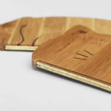 Close-up of a wooden ruler with engraved markings on a light background, showcasing its edge and precise craftsmanship.
