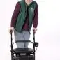 Man in hat and green vest using a U-Step walker for mobility support, white background.