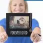 Woman holds a Forever Loved pet photo frame with a dog image, featuring a metal paw charm.
