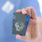 Hand holds wallet with dog engraving and visible blue card, showcasing a stylish and functional design.