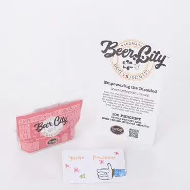 Beer City Dog Biscuits display with empowering message and hand-drawn card, promoting disabled employment.