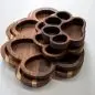 Stack of wooden trays shaped like a dog paw on a white surface.