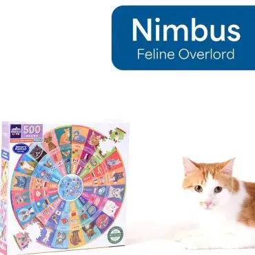 Cat beside colorful 500-piece round puzzle box of cat images, labeled Nimbus, Feline Overlord.