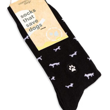Black socks with white dog design, tag reads socks that save dogs, by Conscious Step. Eco-friendly and charity-focused.