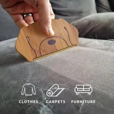 Hand using pet hair remover tool on couch, ideal for cleaning clothes, carpets, and furniture.