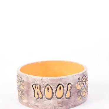 Decorative dog bowl with Woof text and paw prints, perfect for pet lovers and stylish feeding areas.
