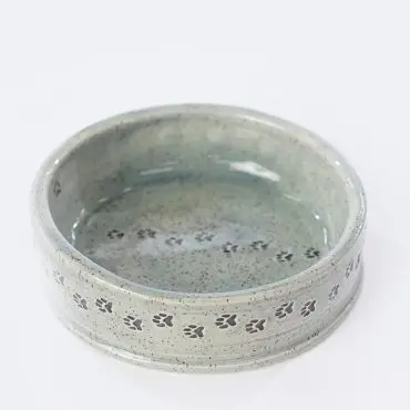 Ceramic pet bowl with paw print design on the rim, speckled glaze finish. Perfect for small dogs or cats.