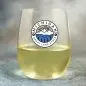 Clear glass with Michigan Great Lake State design, containing white wine, on a blue background.