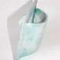 Abstract blue ceramic sculpture with curved design and textured surface, displayed against a white background.
