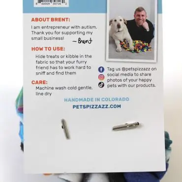 Back of product packaging with brand details, usage instructions, and photo of creator with a dog.