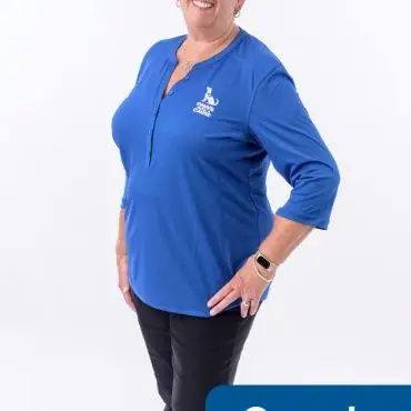 Smiling woman wearing a blue Paws for Cause shirt, labeled as volunteer, standing against a white background.