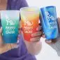Colorful Paws With a Cause cups being held, featuring vibrant blue and orange hues.