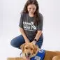 Woman kneeling next to a service dog in a Paws With A Cause vest, on a white background.