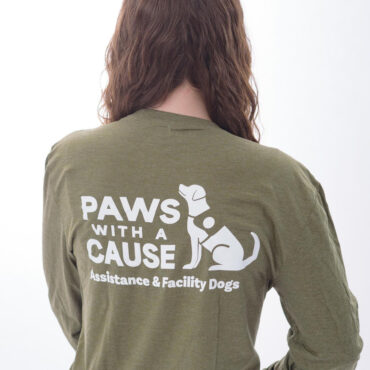 Person wearing a Paws with a Cause shirt, promoting assistance and facility dogs nonprofit.
