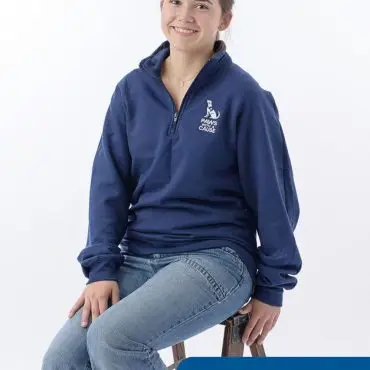 Volunteer in blue Paws for a Cause sweatshirt smiling while seated, promoting animal charity work.