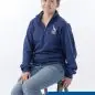 Volunteer in blue Paws for a Cause sweatshirt smiling while seated, promoting animal charity work.