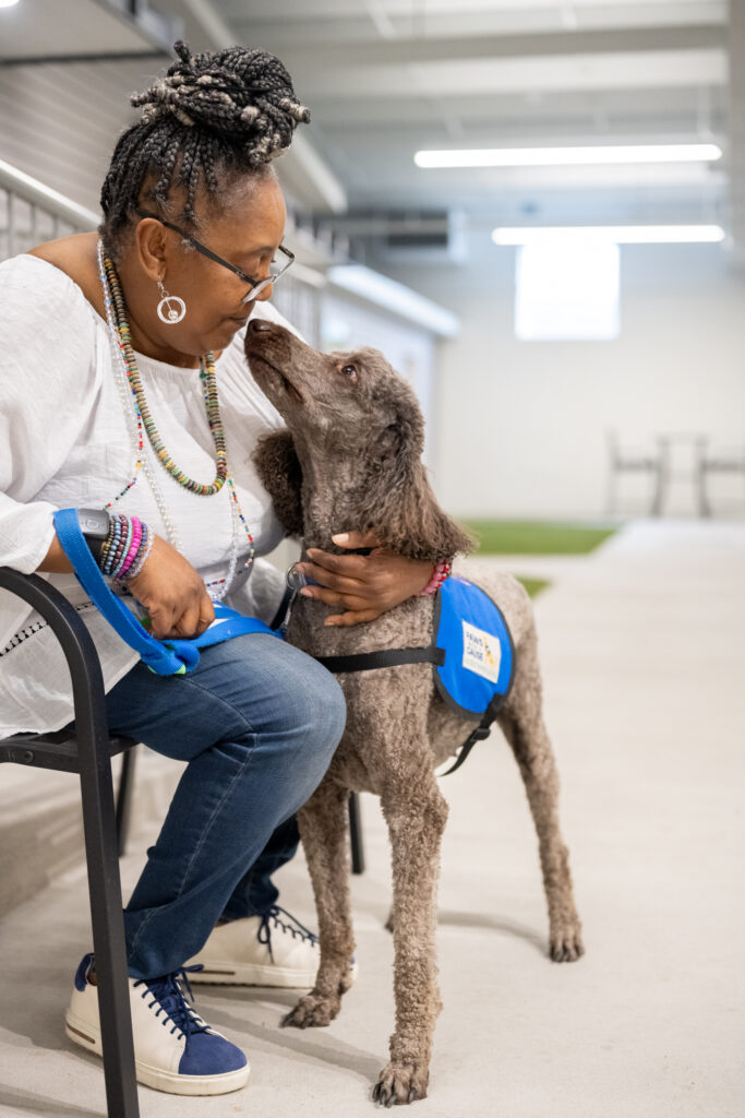 Woman with therapy dog sharing a moment indoors, close interaction enhancing emotional connection and support.