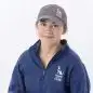 Person wearing Paws with a Cause gear, dark gray cap, and blue sweatshirt, smiling, against a white background.