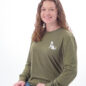 Smiling person wearing green dog-themed shirt and jeans, isolated on white background.