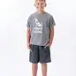 Smiling child wearing a Paws with a Cause T-shirt, shorts, and blue Crocs against a white background.