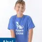 Young volunteer smiling in a Paws With a Cause shirt, standing with hands on a stool.