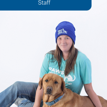 Woman wearing a blue beanie with a dog, promoting Paws with a Cause organization. Friendly and engaging portrait.
