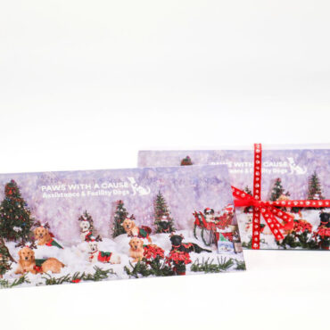 Holiday cards featuring festive dogs and Christmas decorations by Paws With A Cause, supporting assistance dogs.