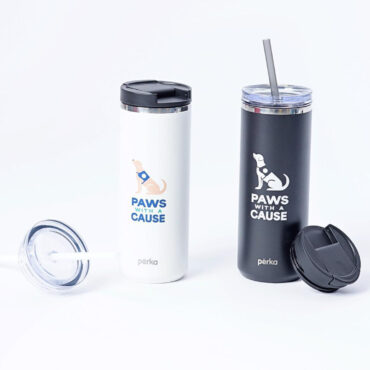White and black Paws with a Cause tumblers by Perka, featuring dog graphics, lids, and a straw, on a white background.