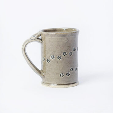 Ceramic mug with paw print design on white background, perfect for pet lovers and cozy tea moments.